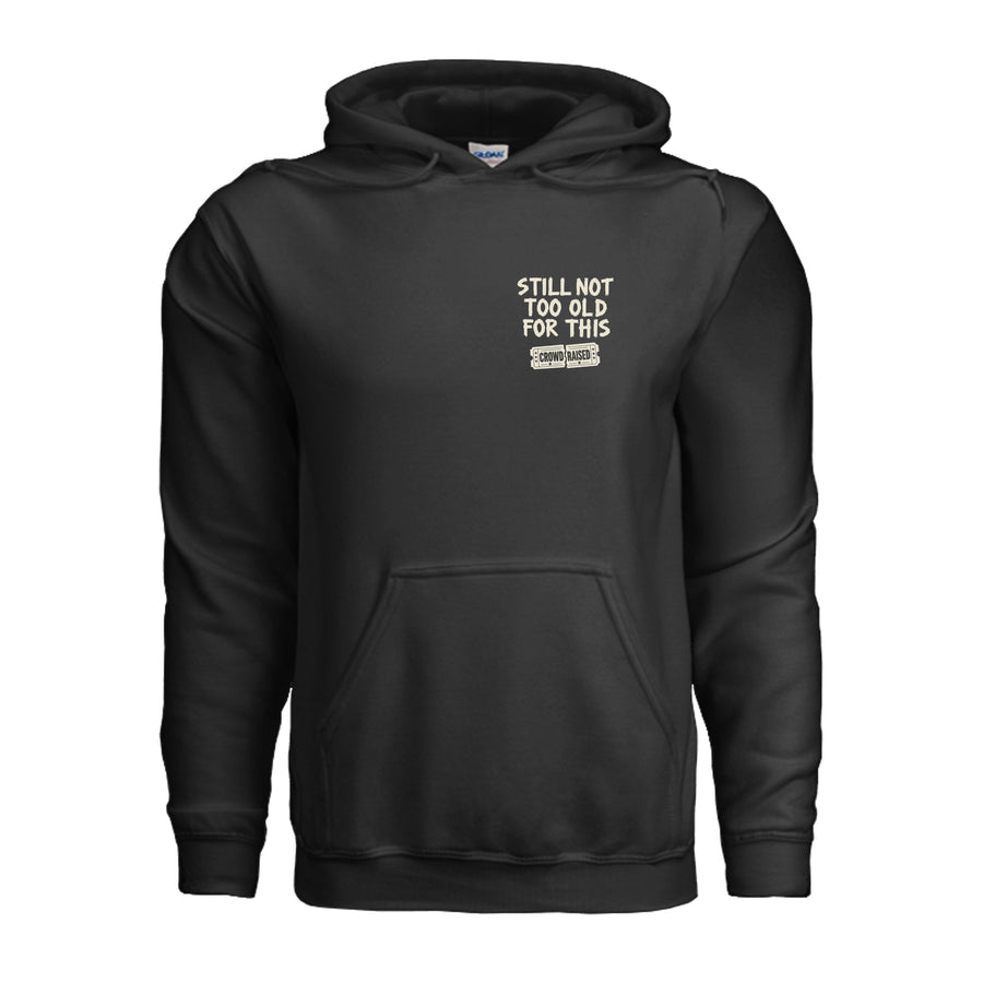 Front of black Crowd Raised hoodie with small cream “Still Not Too Old for This” lettering on the left chest.